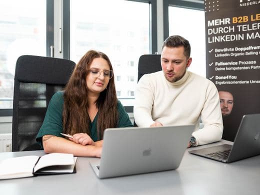 Zwei Mitarbeiter besprechen etwas am Laptop