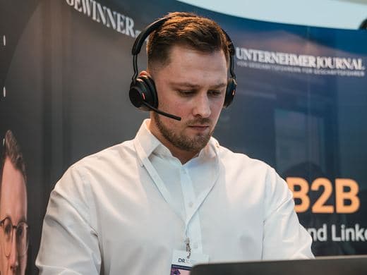 Mitarbeiter mit Headset am Messestand