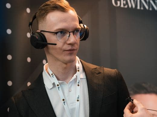 Mitarbeiter mit Headset am Stand der Agentur