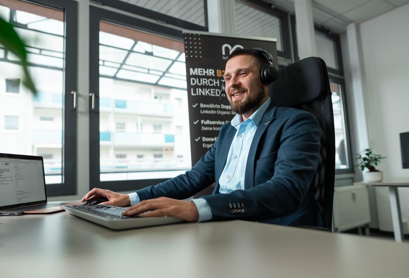 Ein Mitarbeiter der Niederlag Consulting GmbH im Telefonat am Schreibtisch